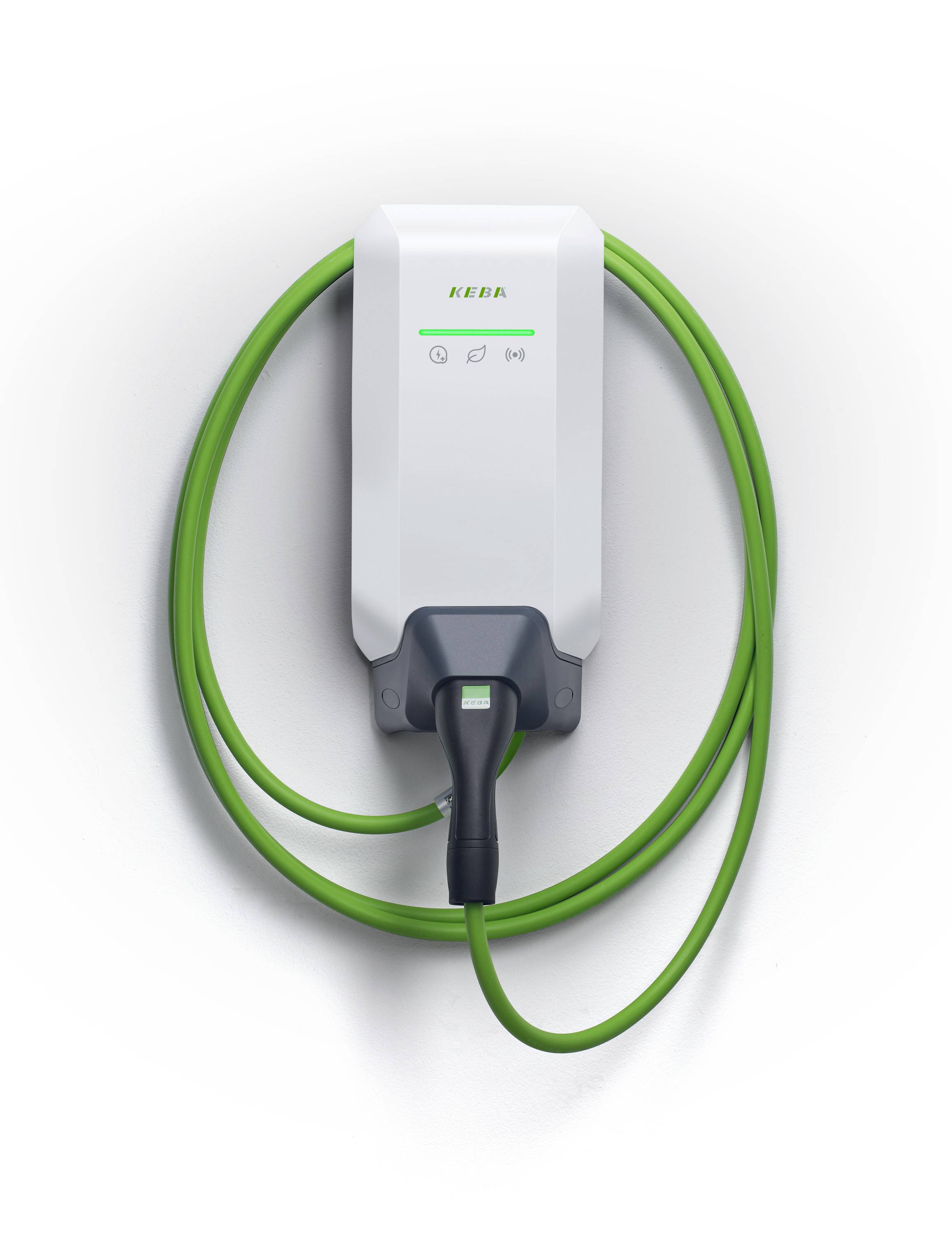 Station de recharge pour véhicules électriques montée au mur avec un câble spiralé vert et un connecteur suspendu sous une unité de chargeur blanc.