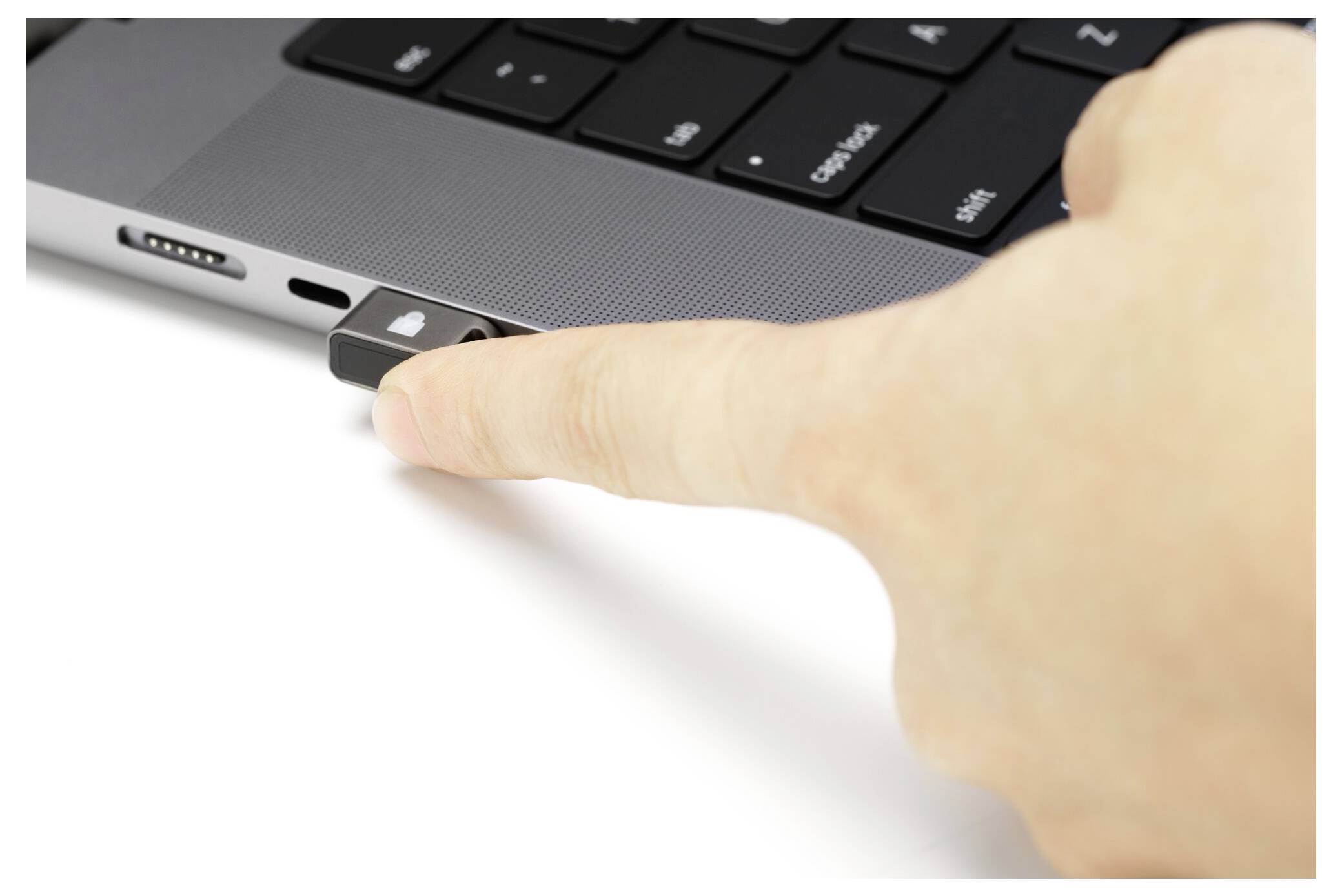 Une main insère une clé USB dans le port latéral d'un ordinateur portable.