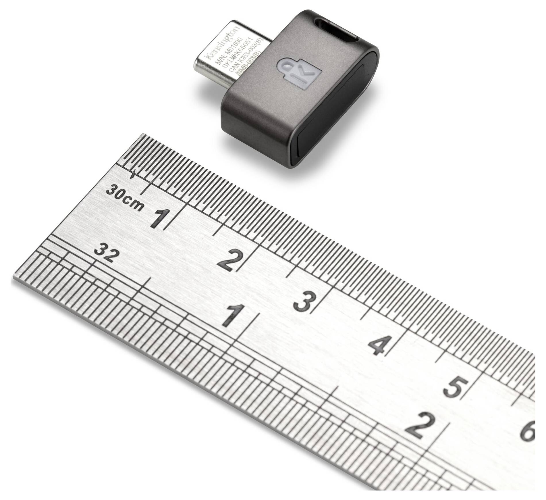 Petit adaptateur USB à côté d'une règle, montrant sa taille compacte.