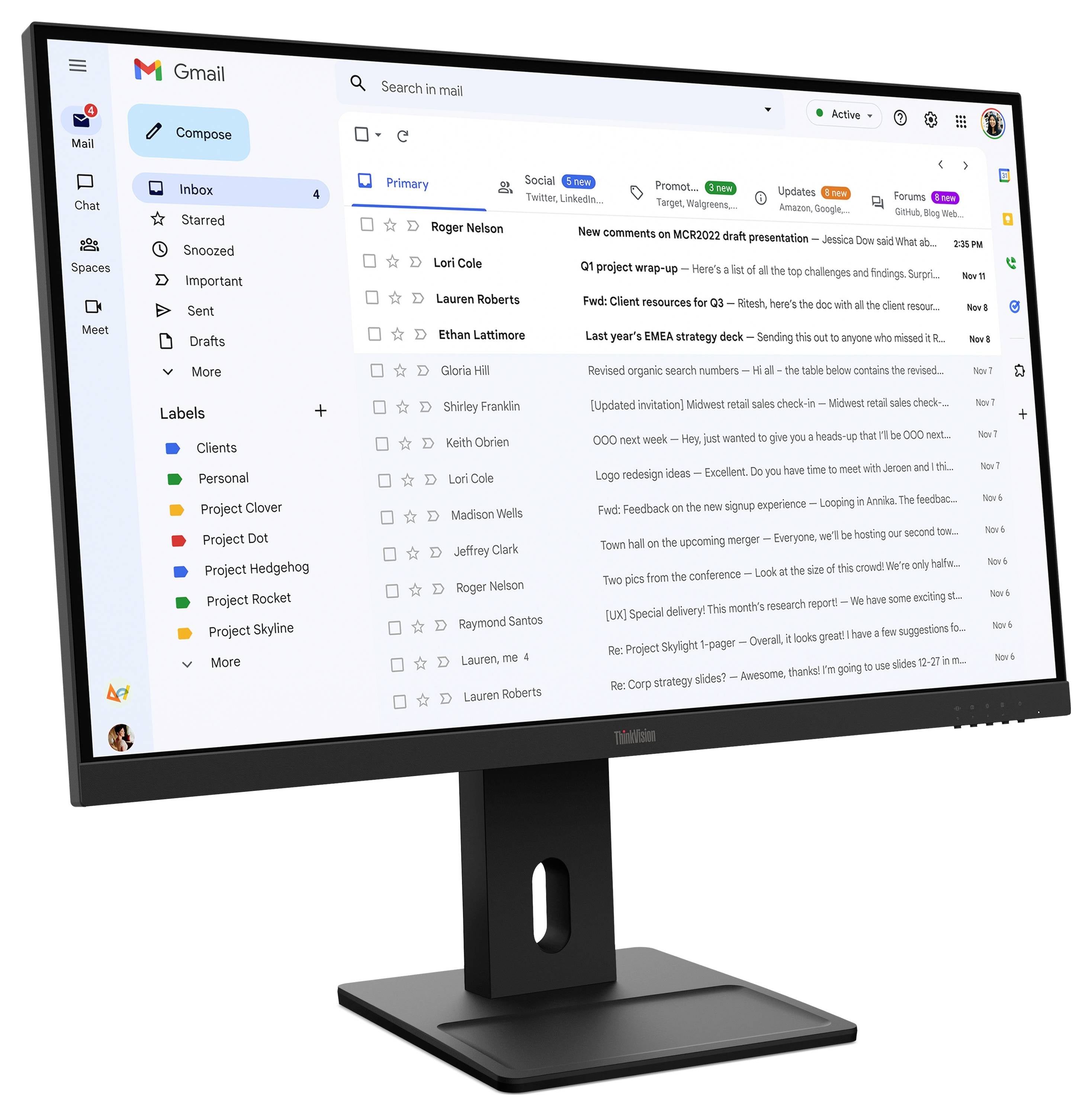 Un moniteur de bureau affiche l'interface de la boîte de réception Gmail avec une barre latérale gauche, une liste de messages et des onglets de catégories en haut.