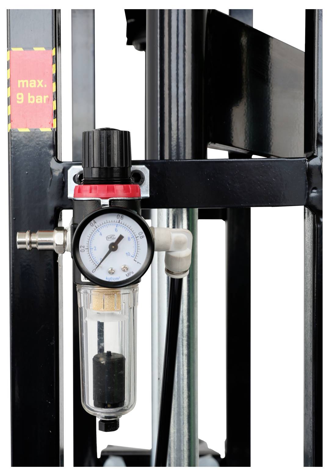 Régulateur de pression d'air industriel avec manomètre et ensemble de filtration, étiqueté « max. 9 bar », monté sur un cadre d'équipement en métal noir.