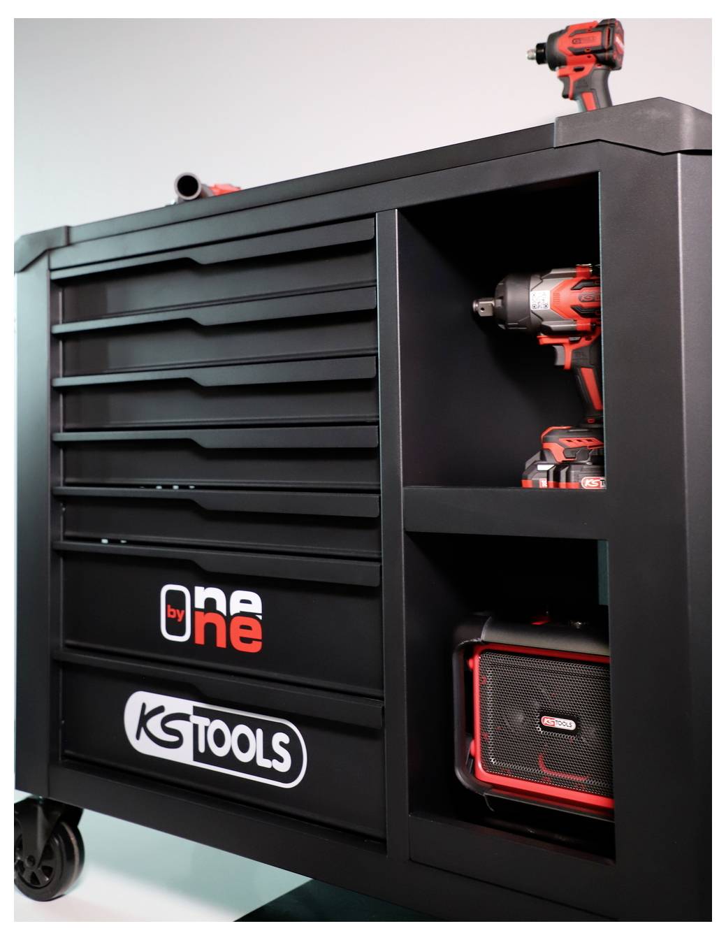 Armoire à outils roulante noire avec tiroirs et étagères ouvertes contenant des outils électriques rouge et noir et un coffret KSTOOLS.