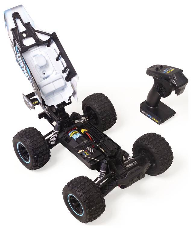 Châssis de voiture tout-terrain radiocommandée avec carrosserie enlevée et son émetteur radio portatif assorti à proximité.