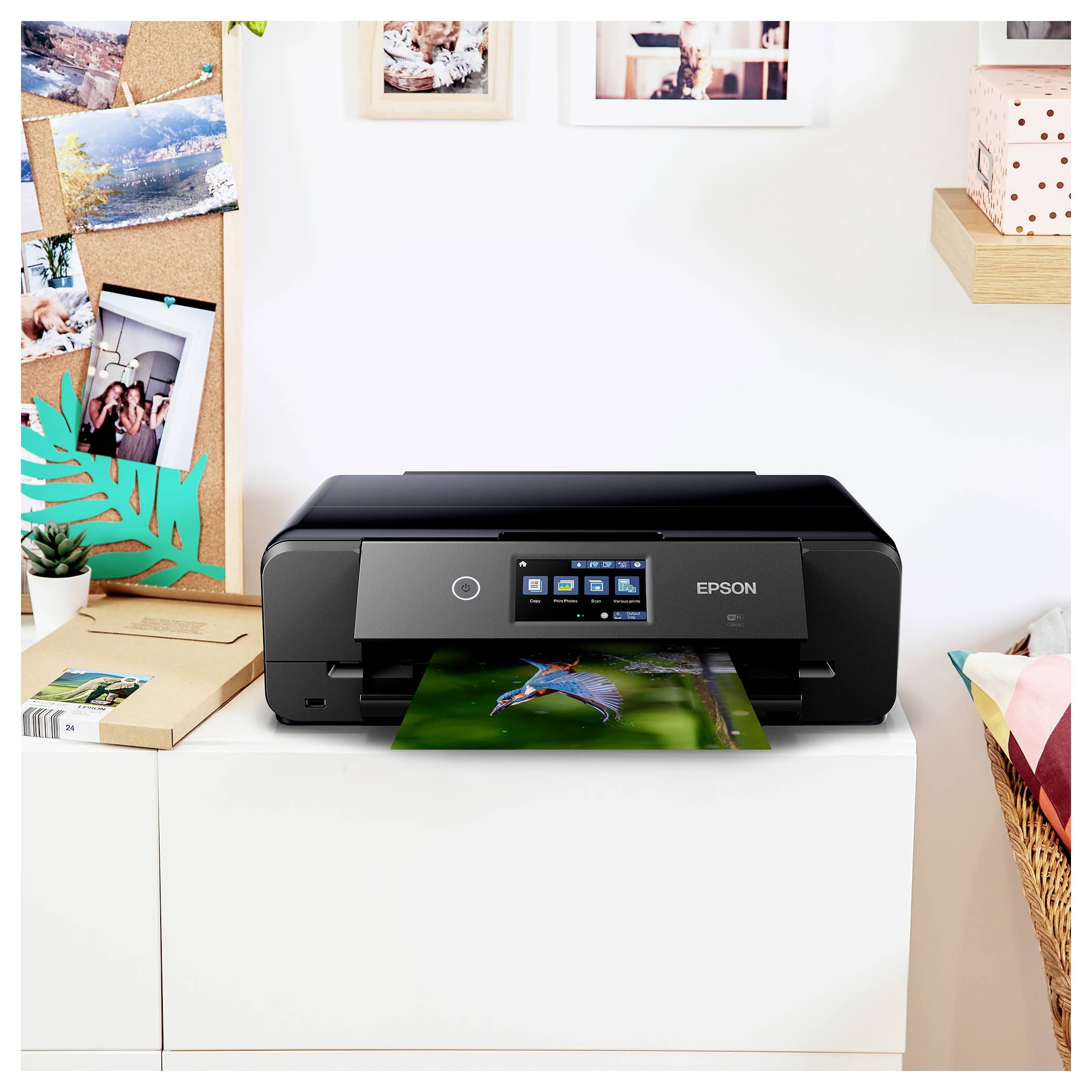 Imprimante Epson noire sur un meuble blanc imprimant une photo colorée, avec un petit écran tactile dans un environnement de bureau à domicile lumineux.