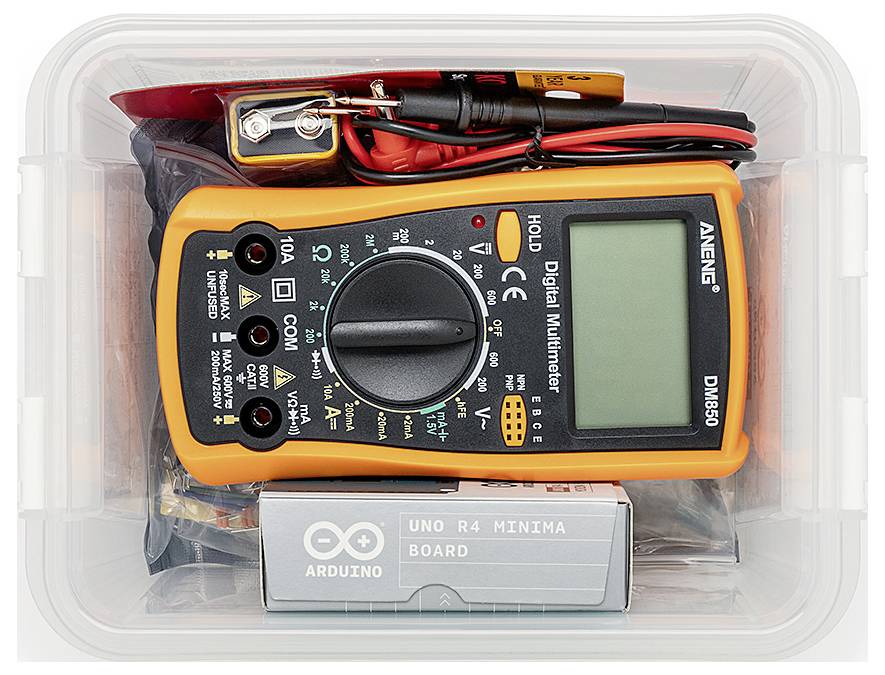 Un multimètre numérique avec des câbles de test et une carte Arduino Uno R4 Minima entreposés dans un conteneur en plastique transparent.