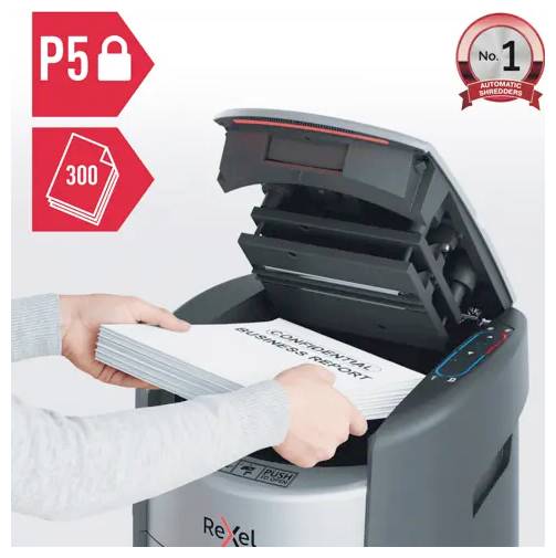 Les mains glissent une pile de documents dans un broyeur automatique Rexel ; les badges indiquent une sécurité P-5 et une capacité de 300 feuilles.
