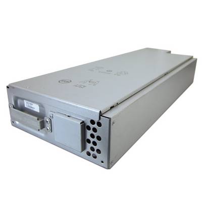 Un appareil électronique métallique rectangulaire, probablement un bloc d'alimentation, est posé sur le côté avec ses fentes de ventilation et ses connecteurs.