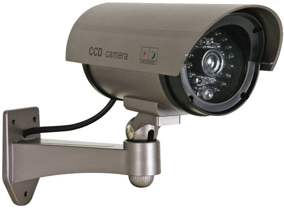 Caméra de surveillance factice fixée au mur, en métal argenté, avec boîtier d'objectif et câble, utilisée comme dispositif dissuasif.