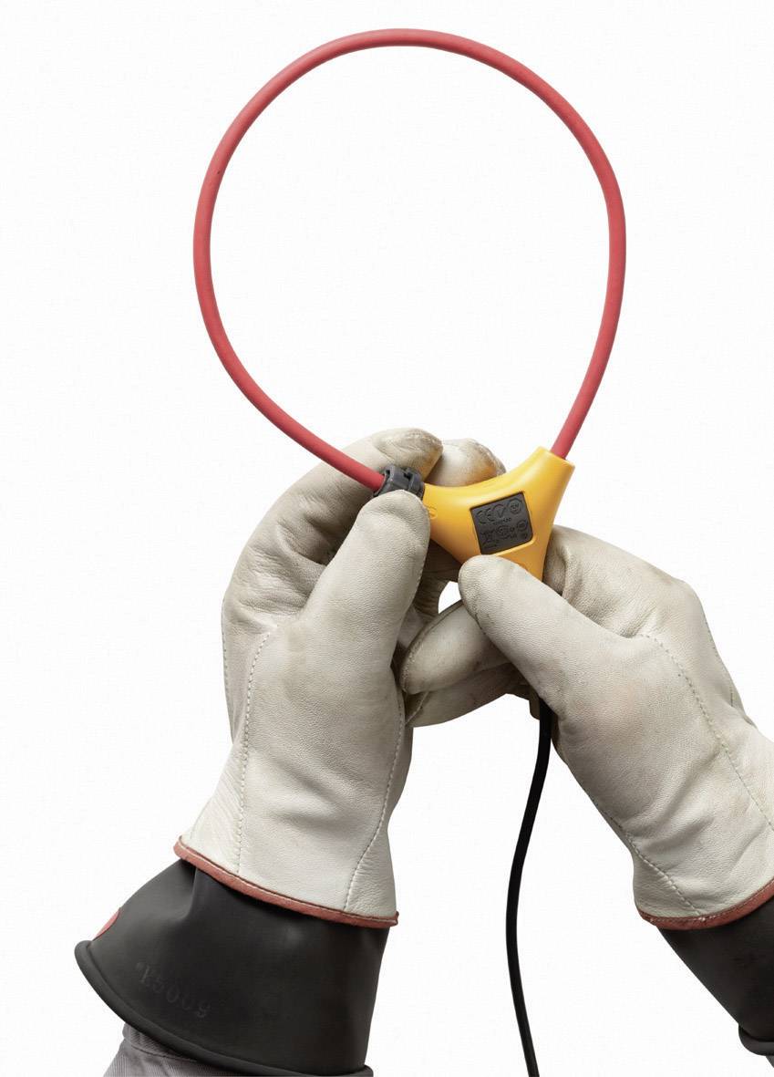 Deux mains gantées tiennent un anneau de mesure électrique rouge, prêtes à être utilisées ou calibrées dans un environnement technique.