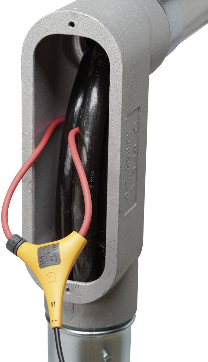 Un appareil électrique muni de câbles est enroulé autour d'un tube noir dans un boîtier métallique, probablement utilisé pour des mesures.