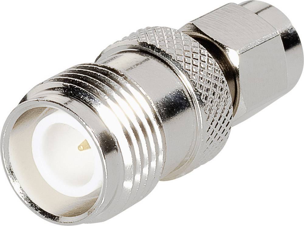 Connecteur coaxial métallique, argenté avec une poignée cannelée, montrant l'ouverture de contact avec un isolant intérieur blanc.