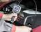 Une personne utilise une caméra d'inspection pour examiner le compartiment moteur d'un véhicule. L'écran affiche une image de l'intérieur.