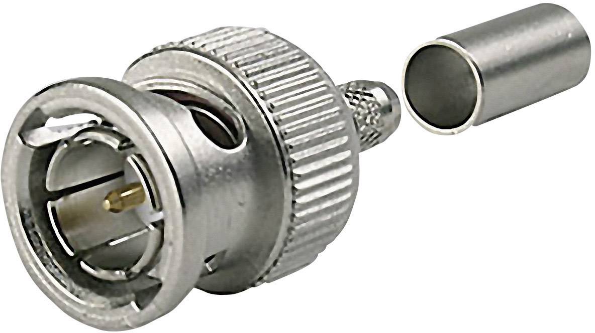 Un connecteur BNC métallique est posé à côté d'un cylindre métallique. Le connecteur possède un boîtier rainuré et des broches apparentes.