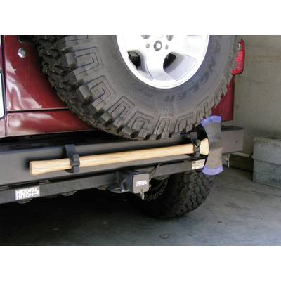 Un pneu de secours est monté à l'arrière d'une voiture. En dessous, une hache avec un manche en bois est fixée à un support.