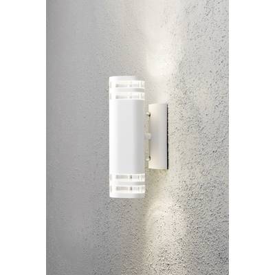 Applique murale blanche au design cylindrique, projetant une lumière dirigée vers le haut et vers le bas sur un mur gris texturé.