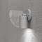 Un luminaire mural extérieur moderne, cylindrique en gris, diffuse de la lumière vers le bas sur un mur rugueux. Idéal pour un éclairage extérieur discret.