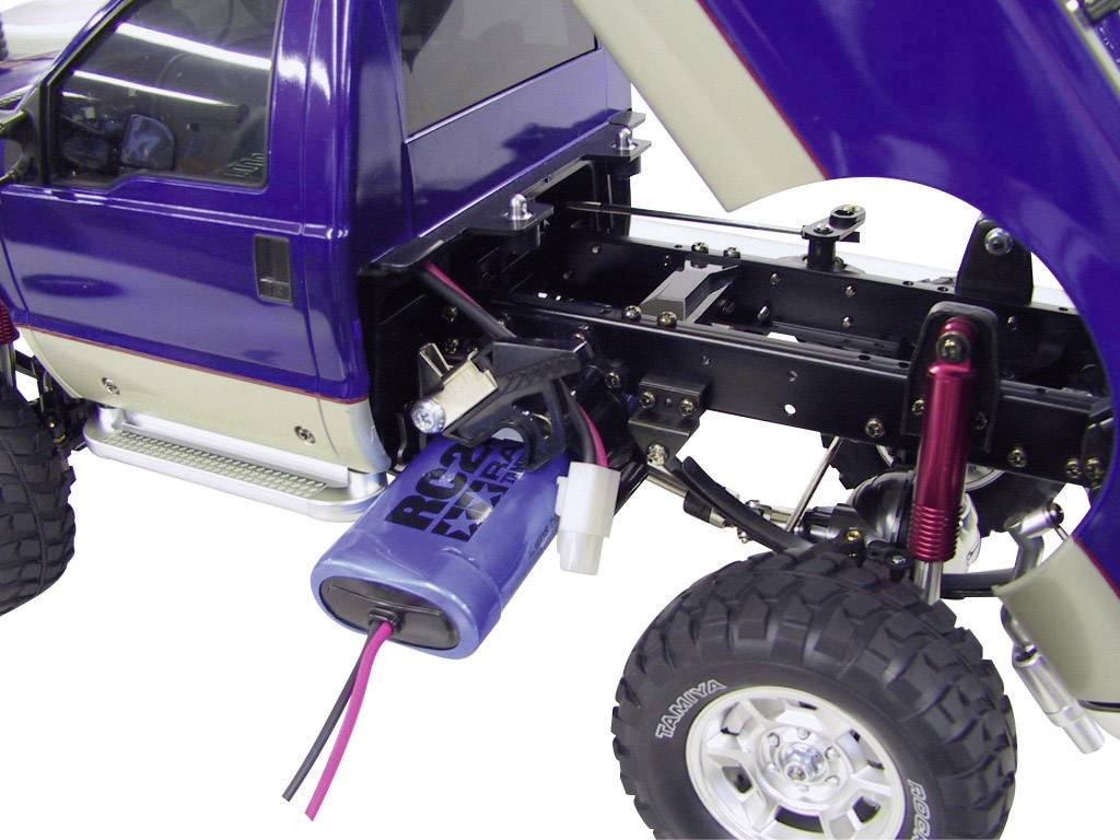 Modèle réduit d'automobile avec un boîtier bleu, capot ouvert et châssis apparent. Les composants électriques et les câbles sont visibles.