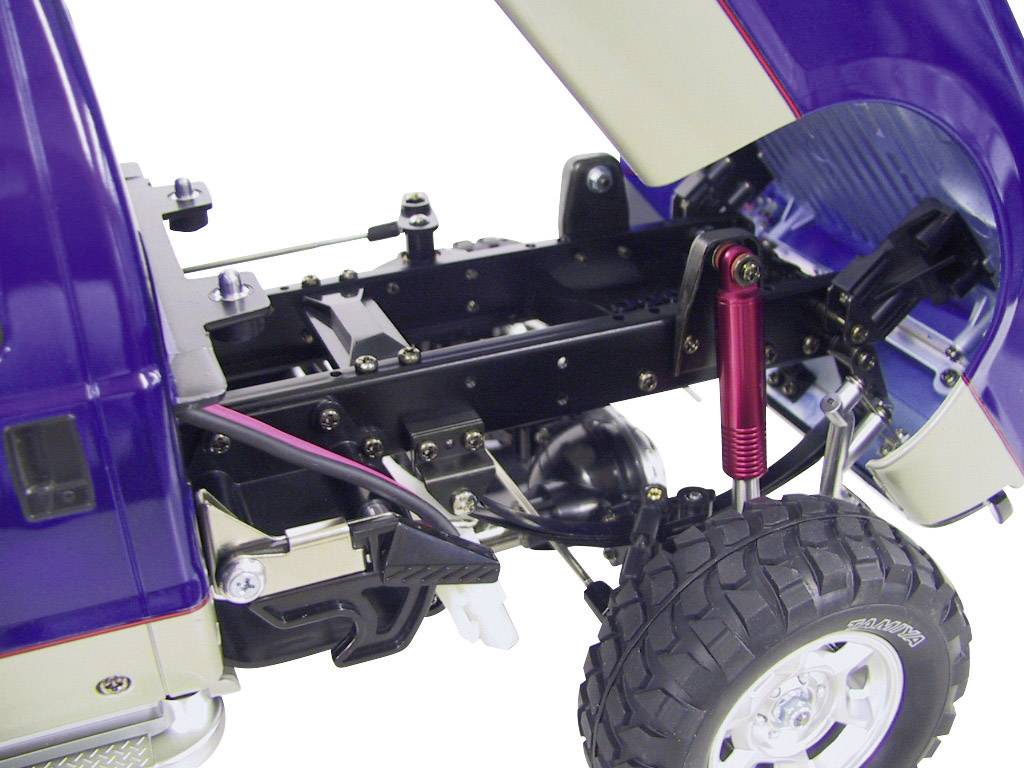 Gros plan d'un châssis de camion miniature bleu avec moteur et suspension mis à nu. Révèle les détails techniques de sa construction.