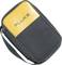 Un sac de transport noir avec un couvercle jaune sur lequel est inscrit 'FLUKE'. Il est doté d'une bandoulière et conçu de manière compacte.