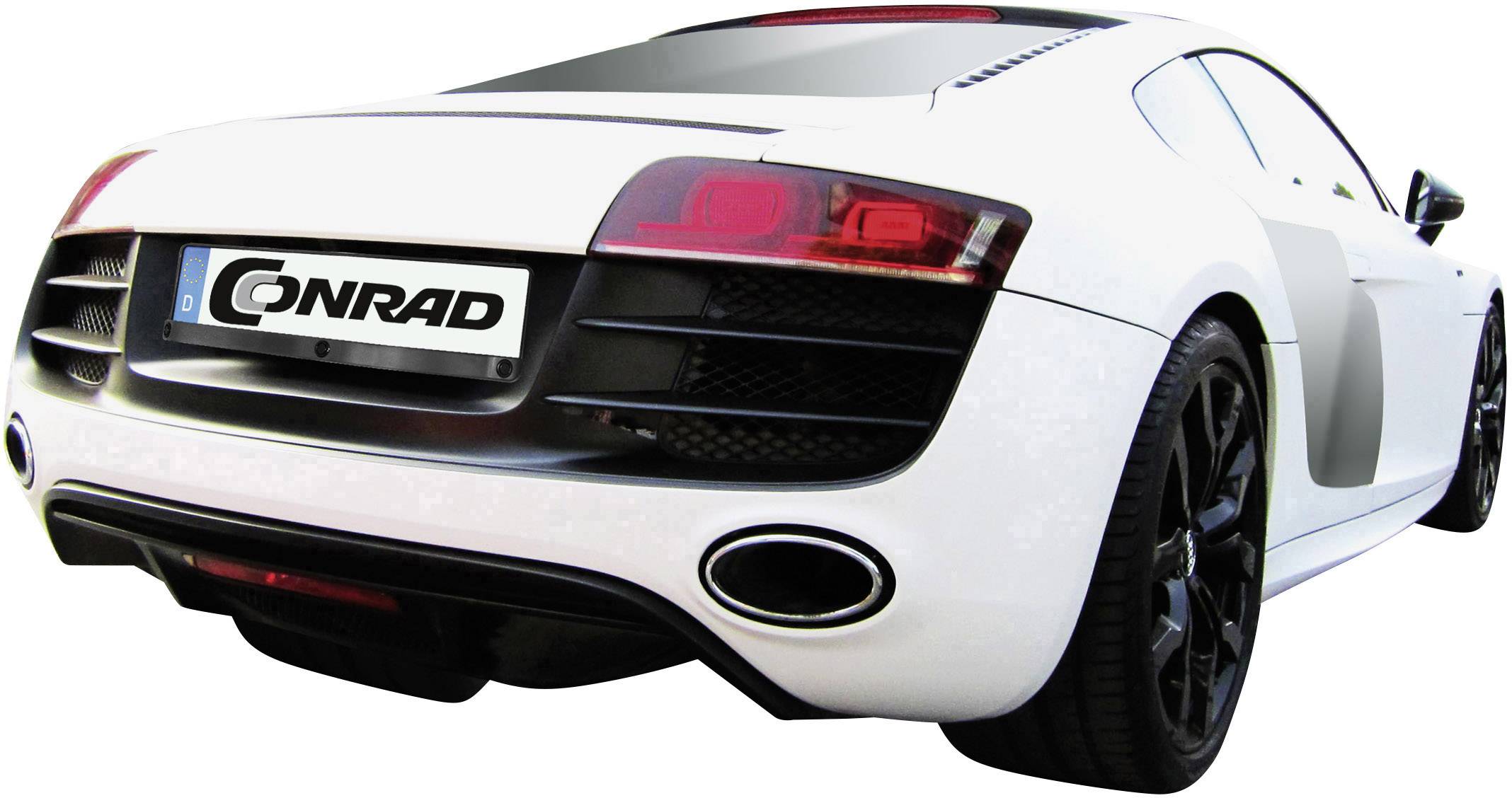 Voiture de sport blanche avec un arrière noir et des feux arrière remarquables. Plaque d'immatriculation : 'Conrad'. La voiture est garée sur l'asphalte.