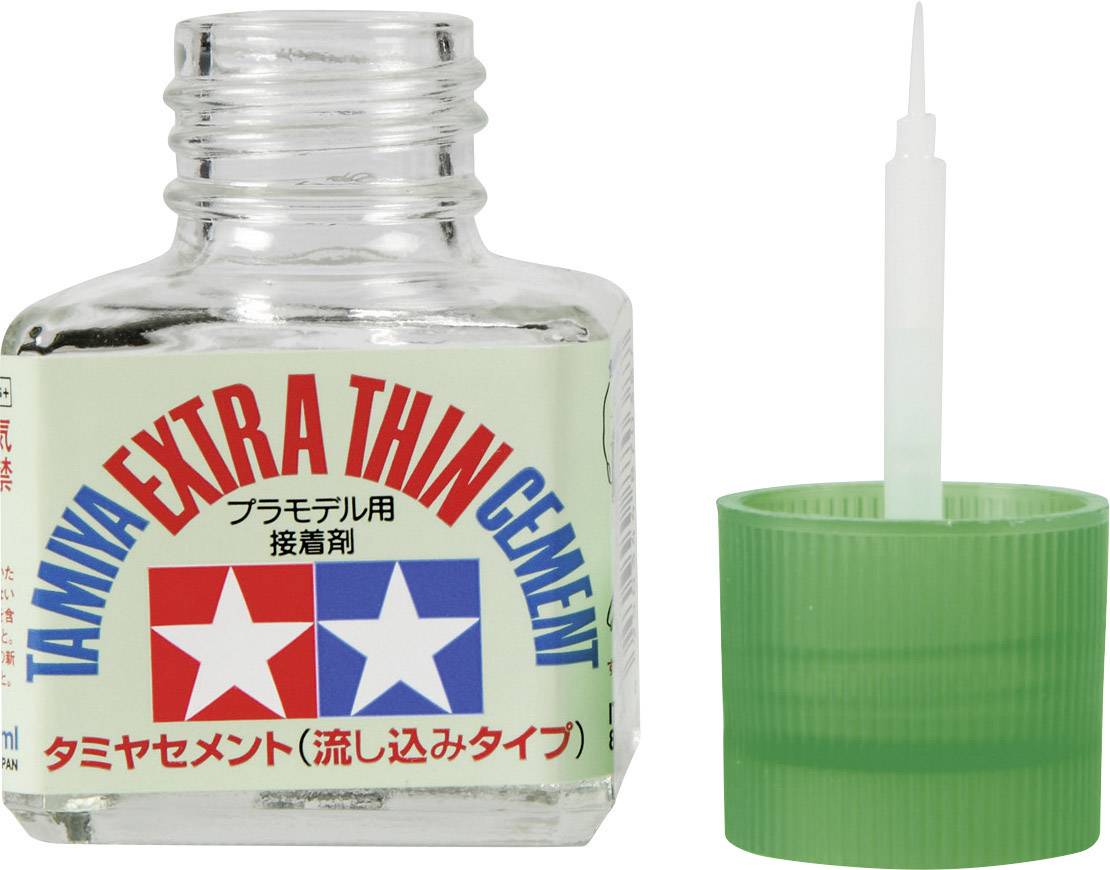 Bouteille de colle 'Tamiya Extra Thin Cement' avec son bouchon vert à côté.