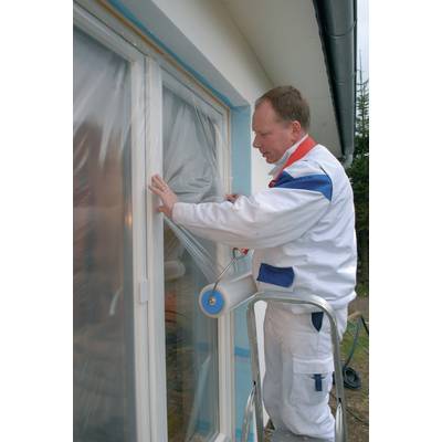 Un homme en tenue de travail est debout sur une échelle et applique un film plastique protecteur sur un cadre de fenêtre, probablement en préparation de travaux de peinture.