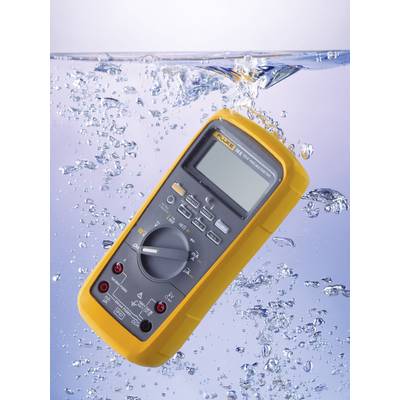 Un multimètre flotte sous l'eau, démontrant son étanchéité. L'appareil possède un boîtier jaune et un avant gris. Des bulles d'air sont visibles.