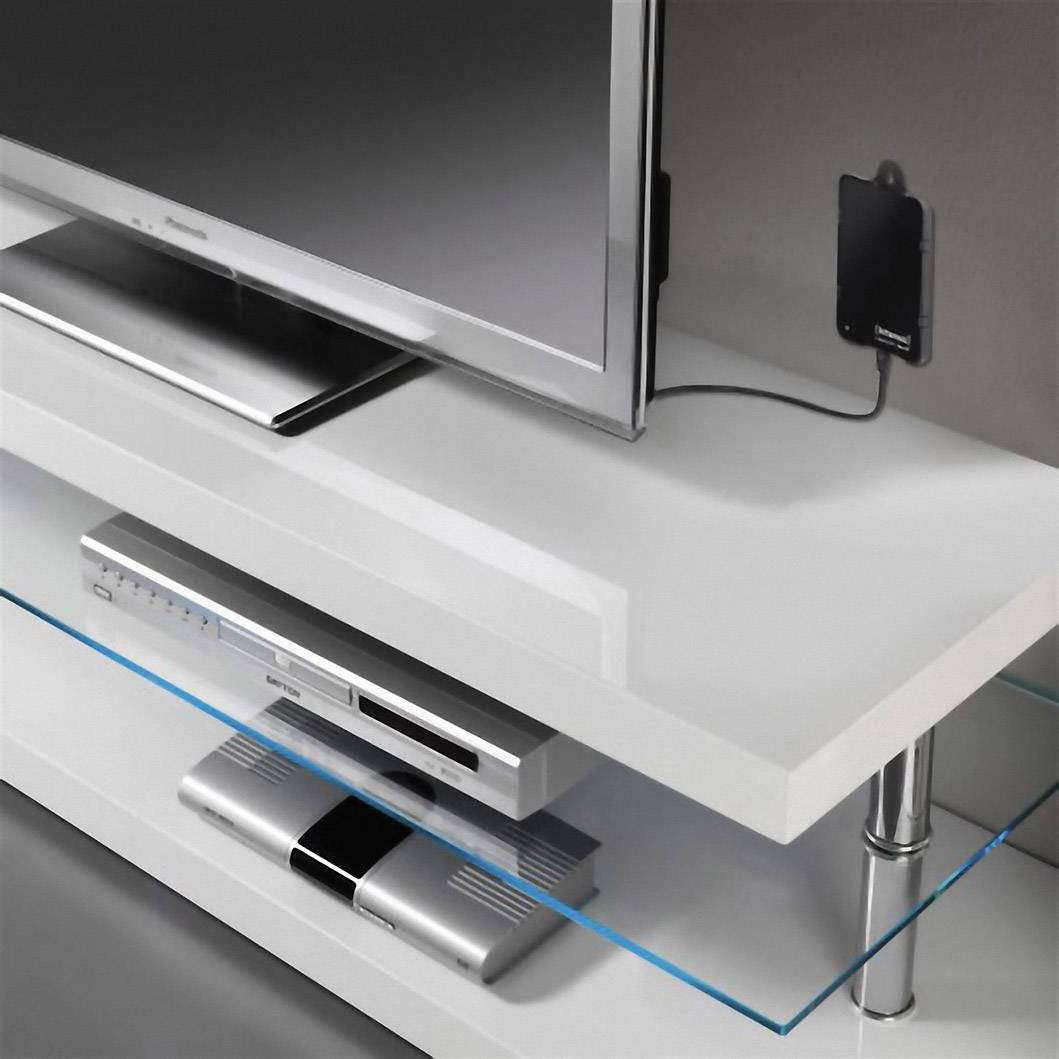 Un téléviseur moderne est posé sur un support blanc, en dessous duquel se trouvent un lecteur DVD et un autre appareil électronique sur une étagère en verre.