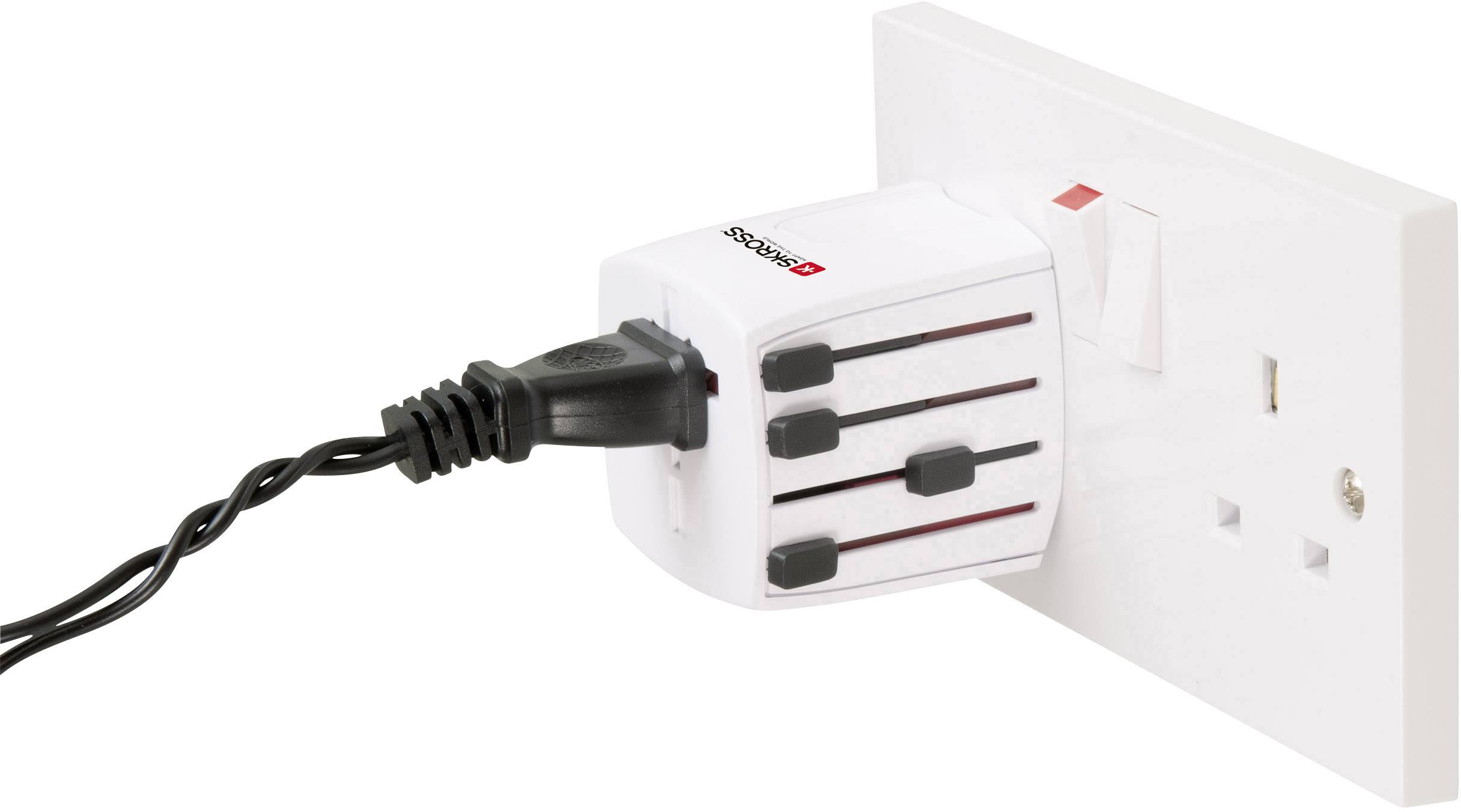 Un adaptateur de voyage universel est branché dans une prise électrique, relié à une fiche noire.