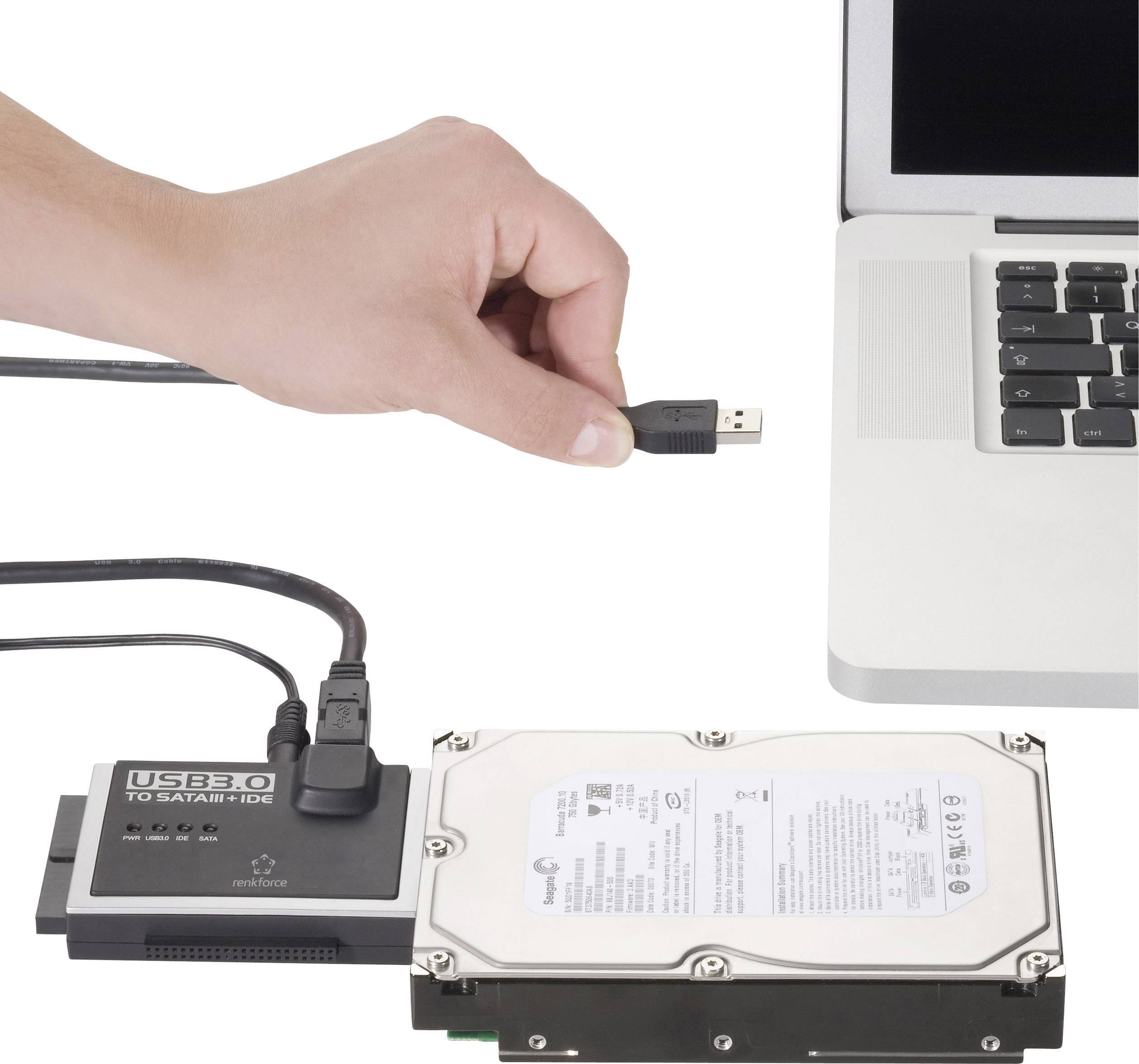 Un adaptateur USB connecte un disque dur externe à un ordinateur portable. Une main tient la fiche USB près du port de l'ordinateur portable.