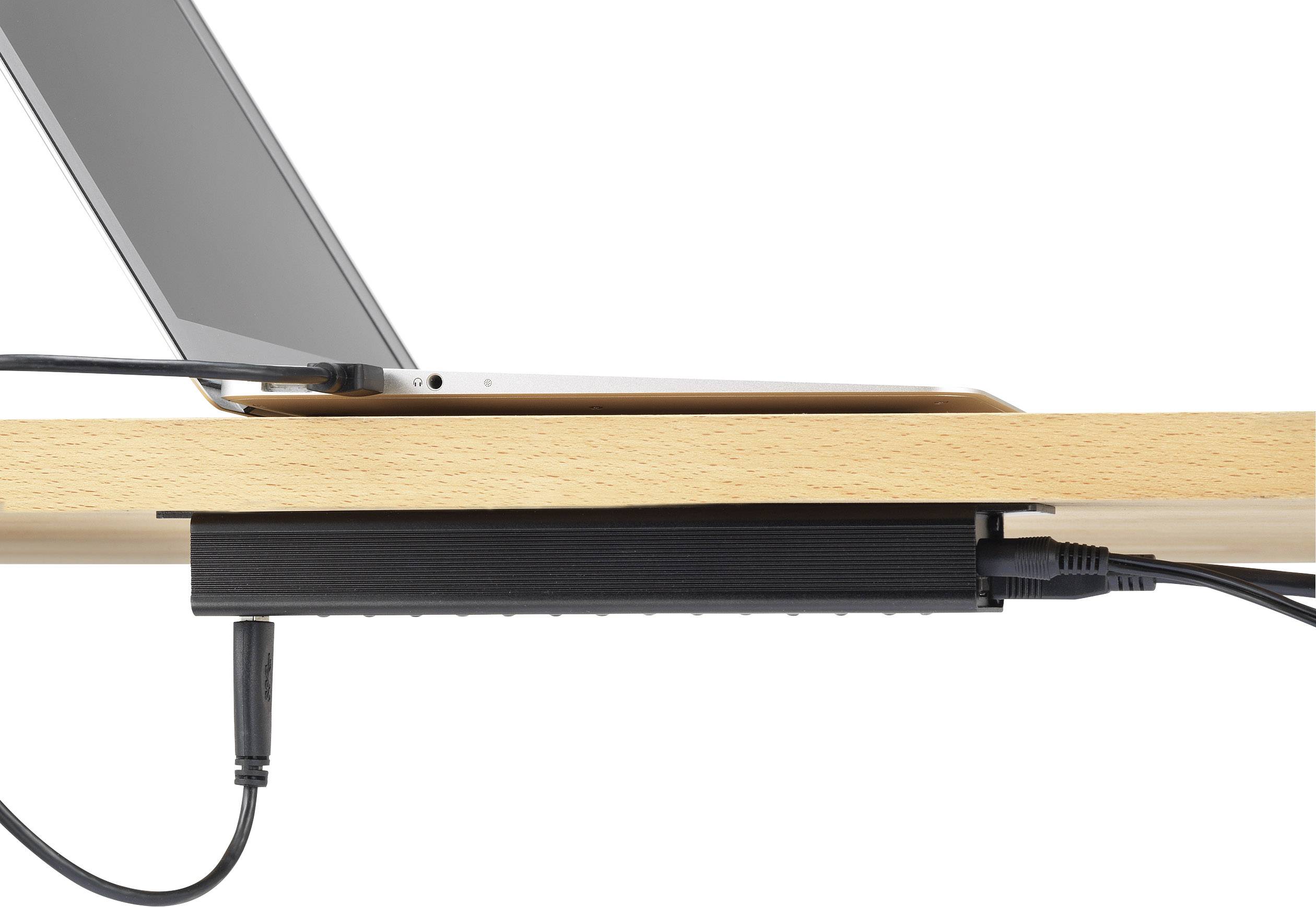 Un ordinateur portable est placé au bord d'une table en bois. Sous la table, les câbles sont soigneusement fixés.