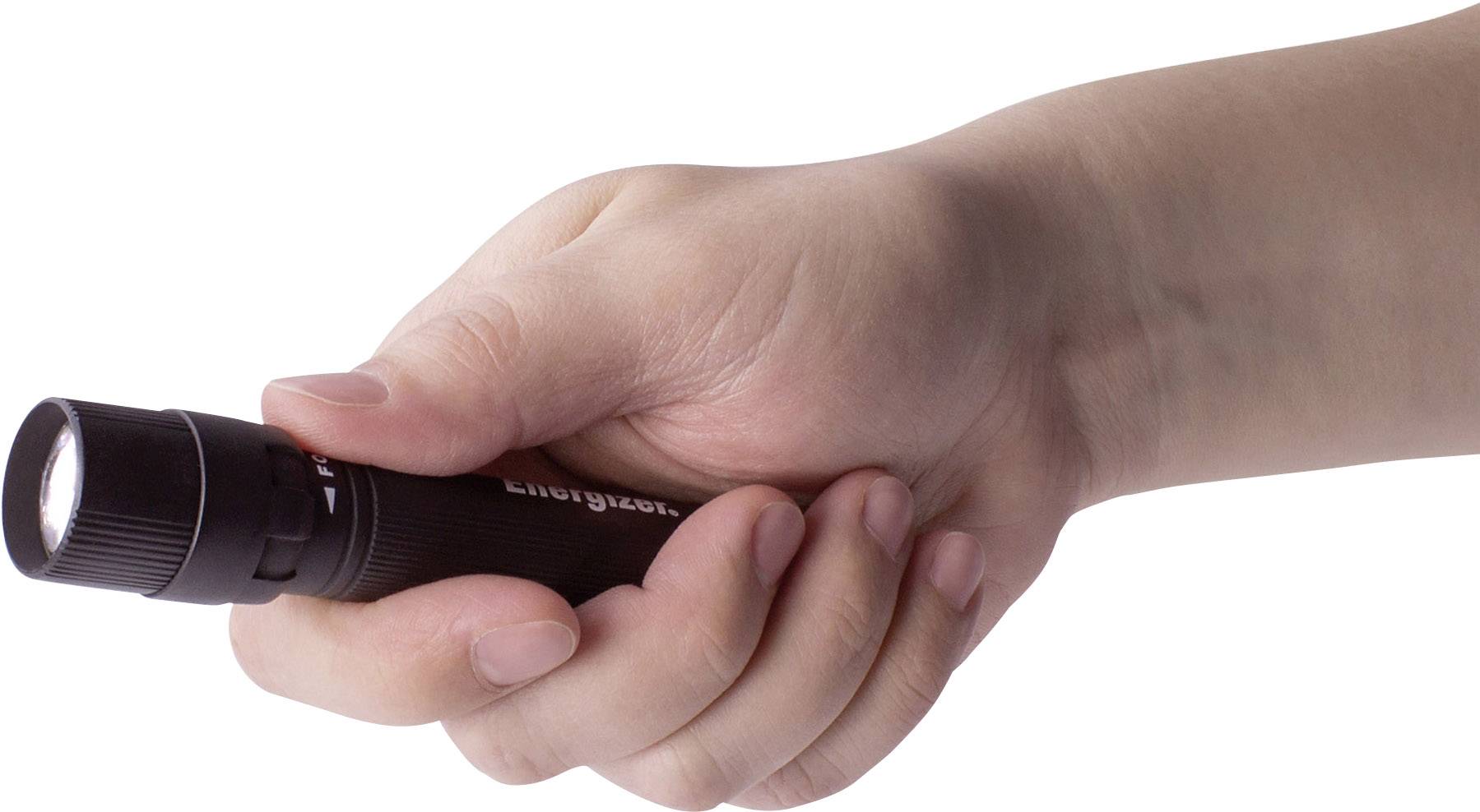 Une main tient une petite lampe de poche noire.