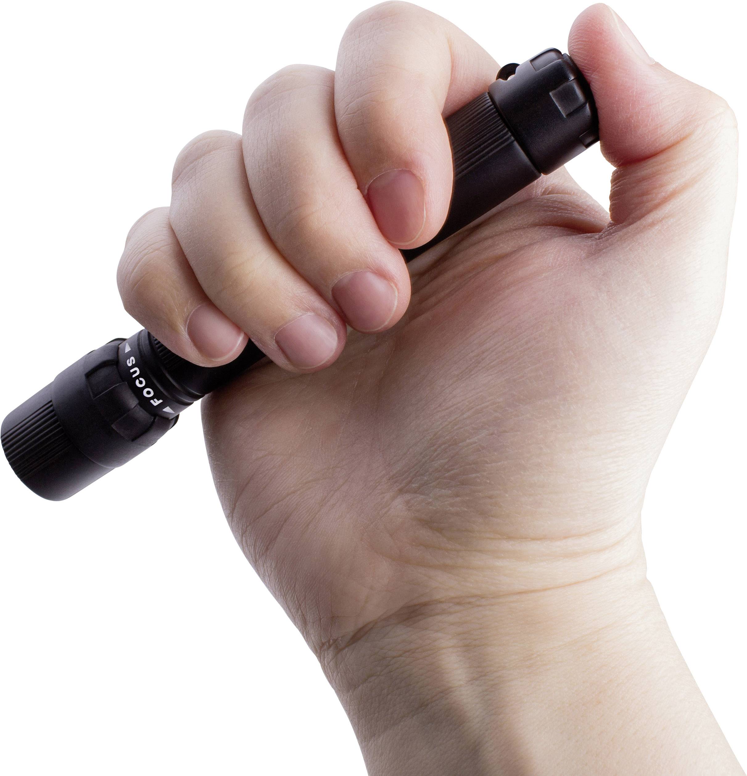 Une main tient fermement une petite lampe de poche noire avec un bouton-poussoir.
