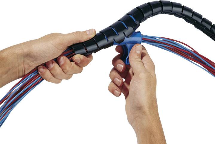 Des mains fixent des câbles avec une spirale de gaine thermorétractable noire pour organiser et protéger les câbles.