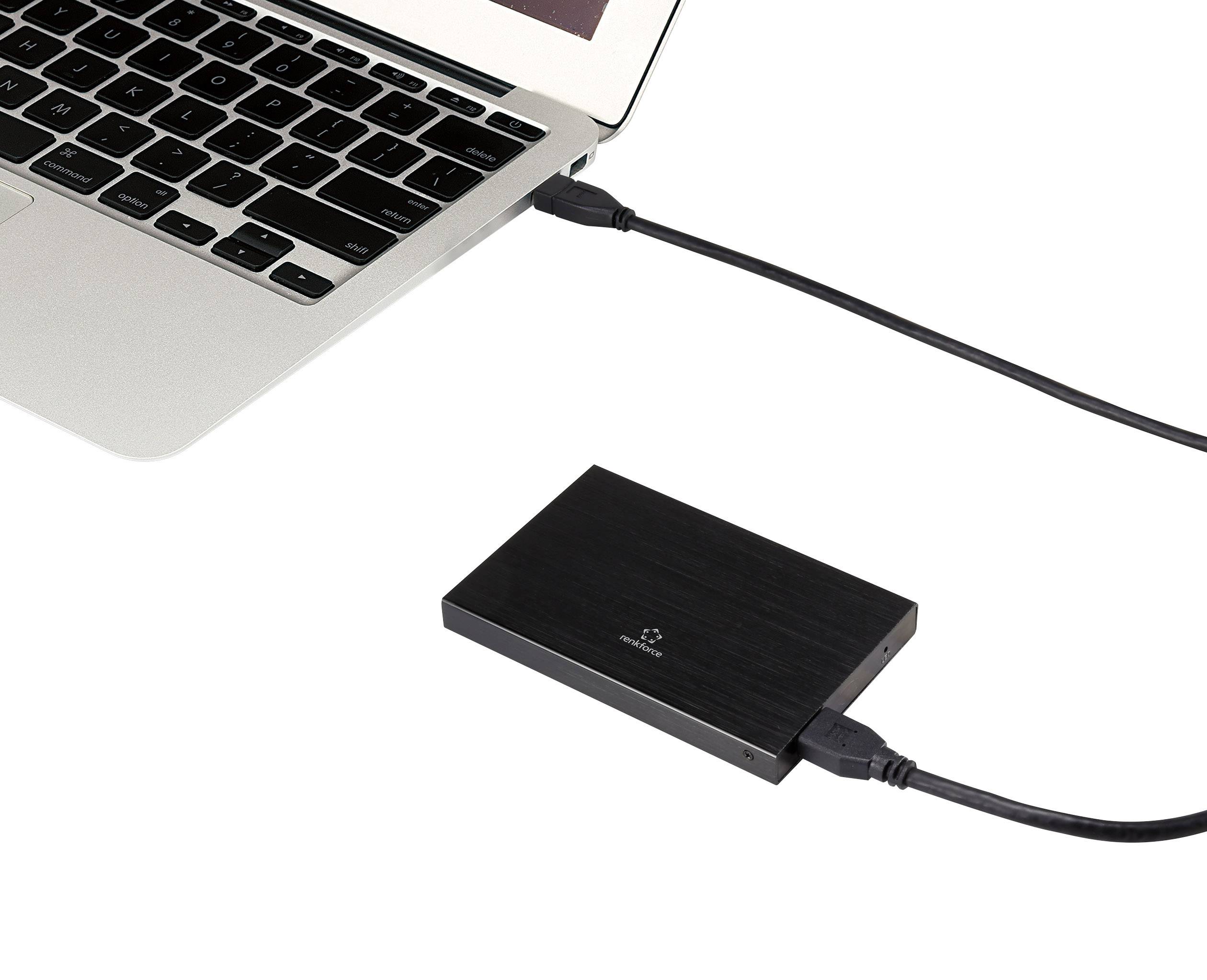 Un ordinateur portable est connecté à un disque dur externe via un câble USB. Le disque dur est posé à côté de l'ordinateur portable sur une surface blanche.