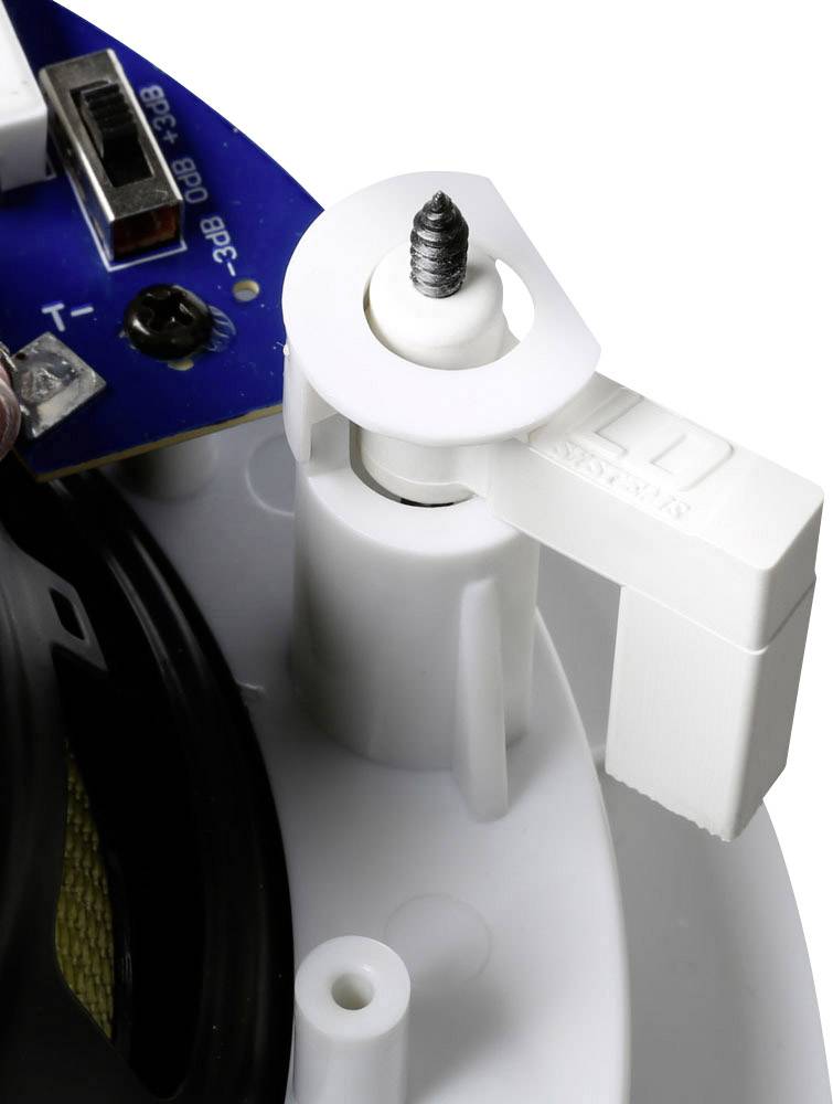 Un clip en plastique blanc avec une vis maintient une carte électronique. À l'arrière-plan, des fils et des composants de circuit imprimé sont visibles.