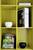 Une étagère jaune avec deux livres '100 Contemporary Houses', un magazine 'TASCHEN's SPAS' et deux enceintes rondes.