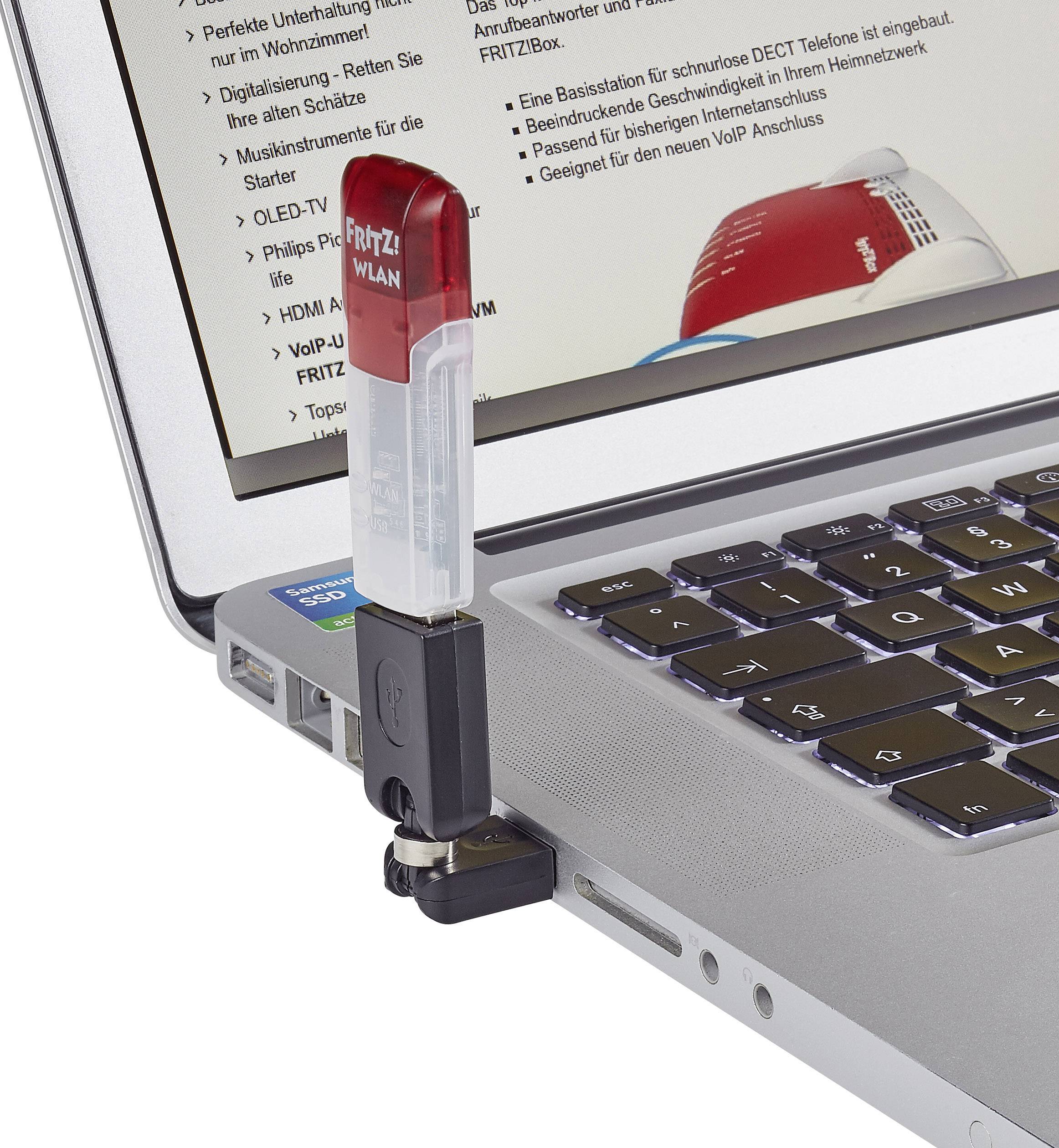 Un ordinateur portable avec une clé WiFi branchée sur un port USB. L'écran affiche des détails techniques.