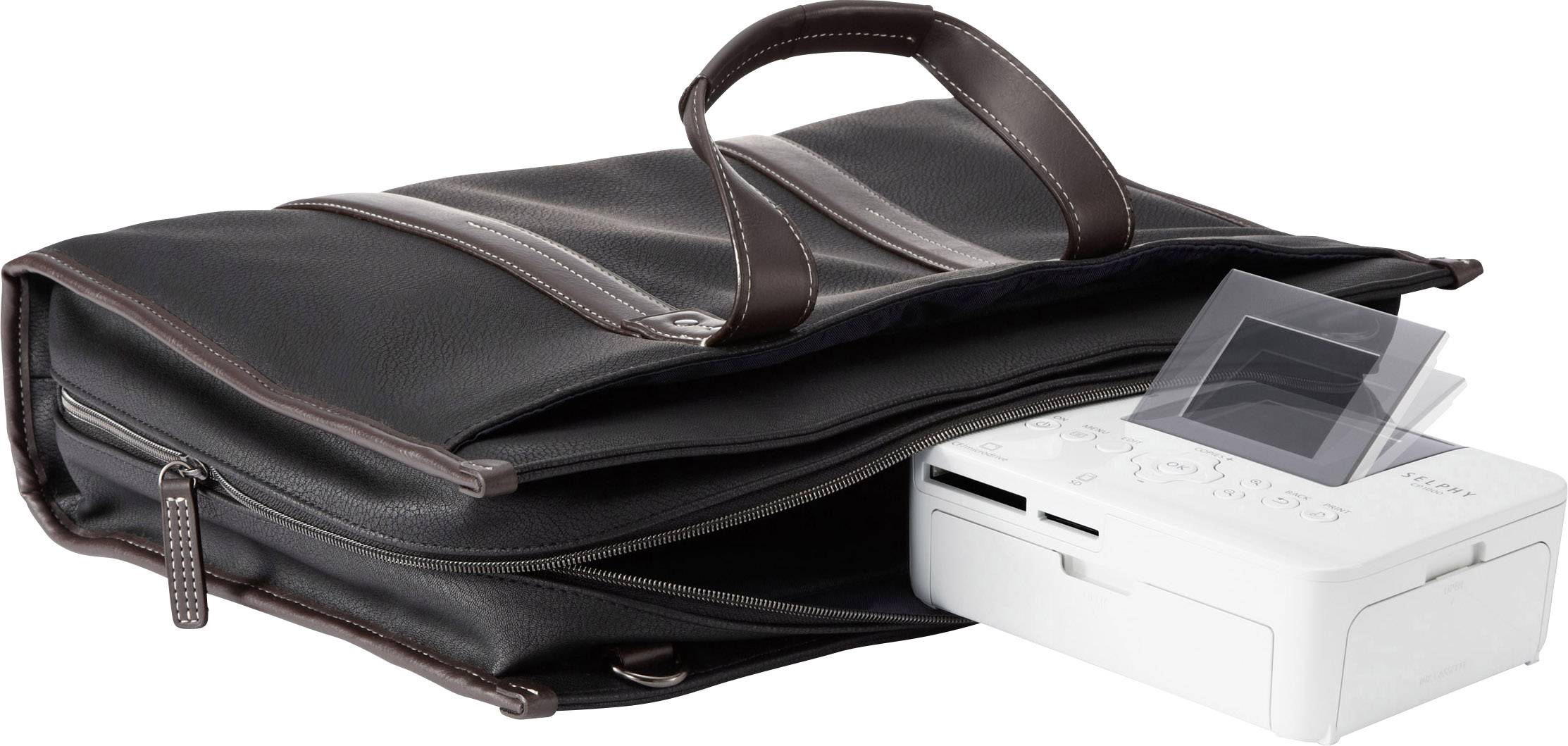 Imprimante photo portable posée à côté d'un sac en cuir noir ouvert. L'appareil dispose d'un écran et de commandes.