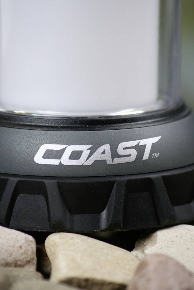 Partie inférieure d'un lampadaire sur des pierres. L'inscription 'COAST' est visible sur le socle.