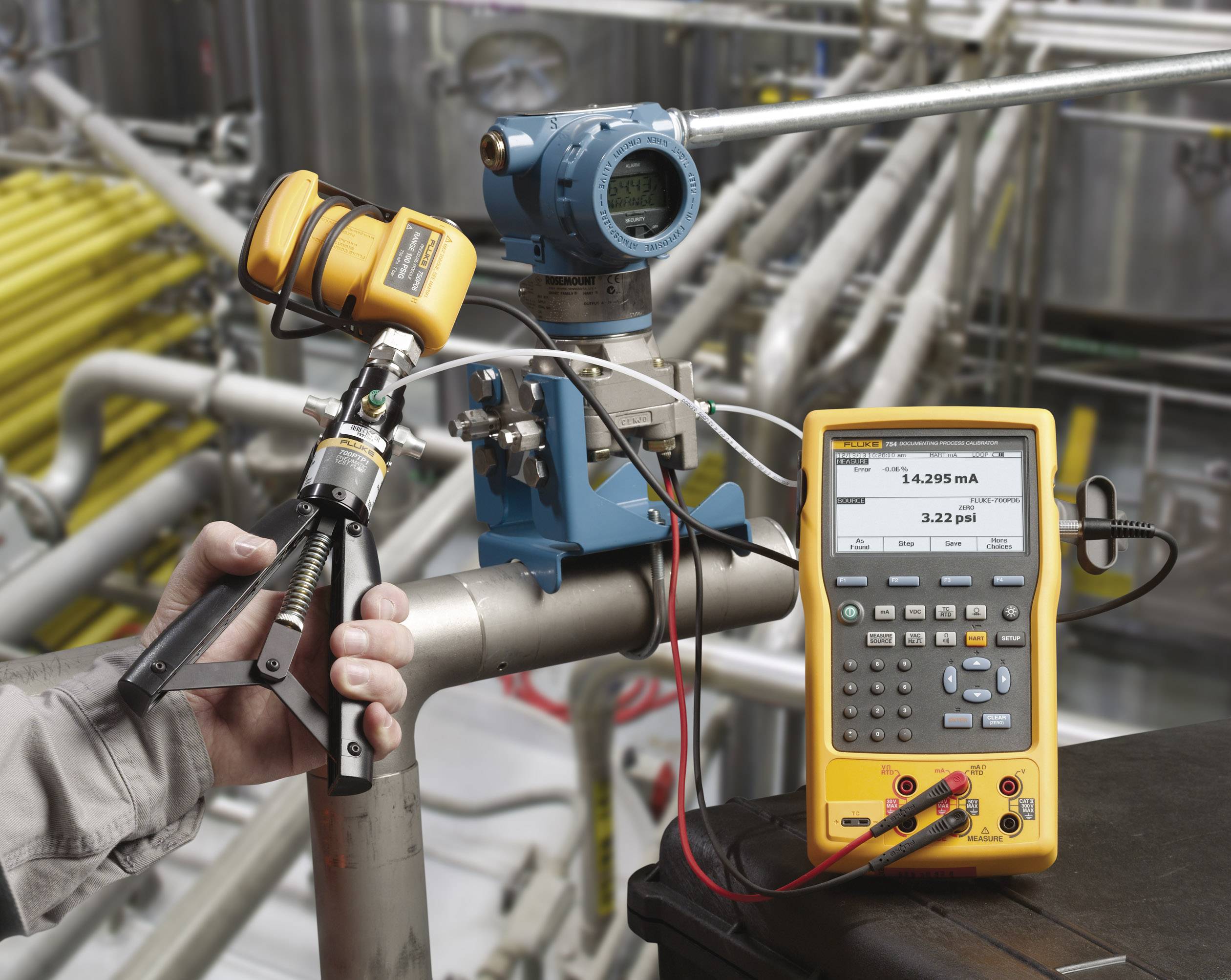 Une personne calibre un capteur de pression dans un environnement industriel à l'aide d'un appareil de calibrage portable.