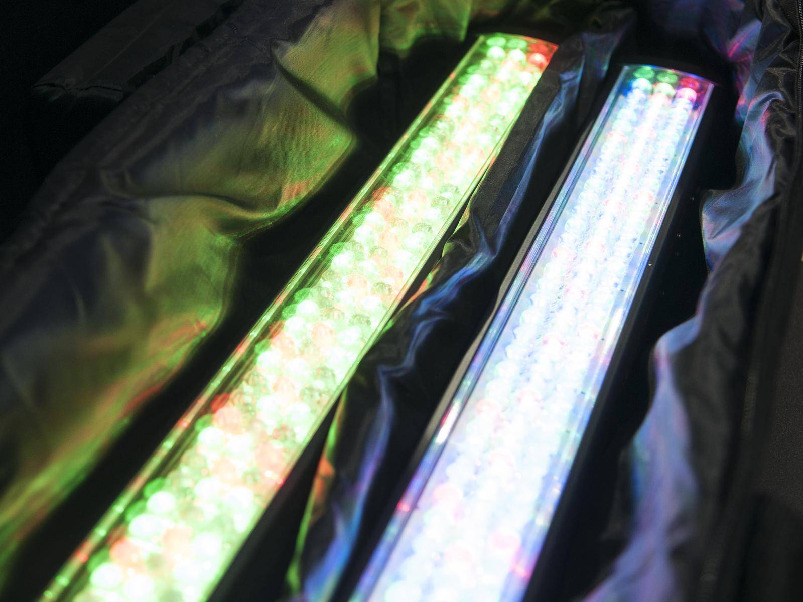 Deux rampes lumineuses LED brillent dans différentes couleurs à l'intérieur d'un boîtier recouvert de tissu.
