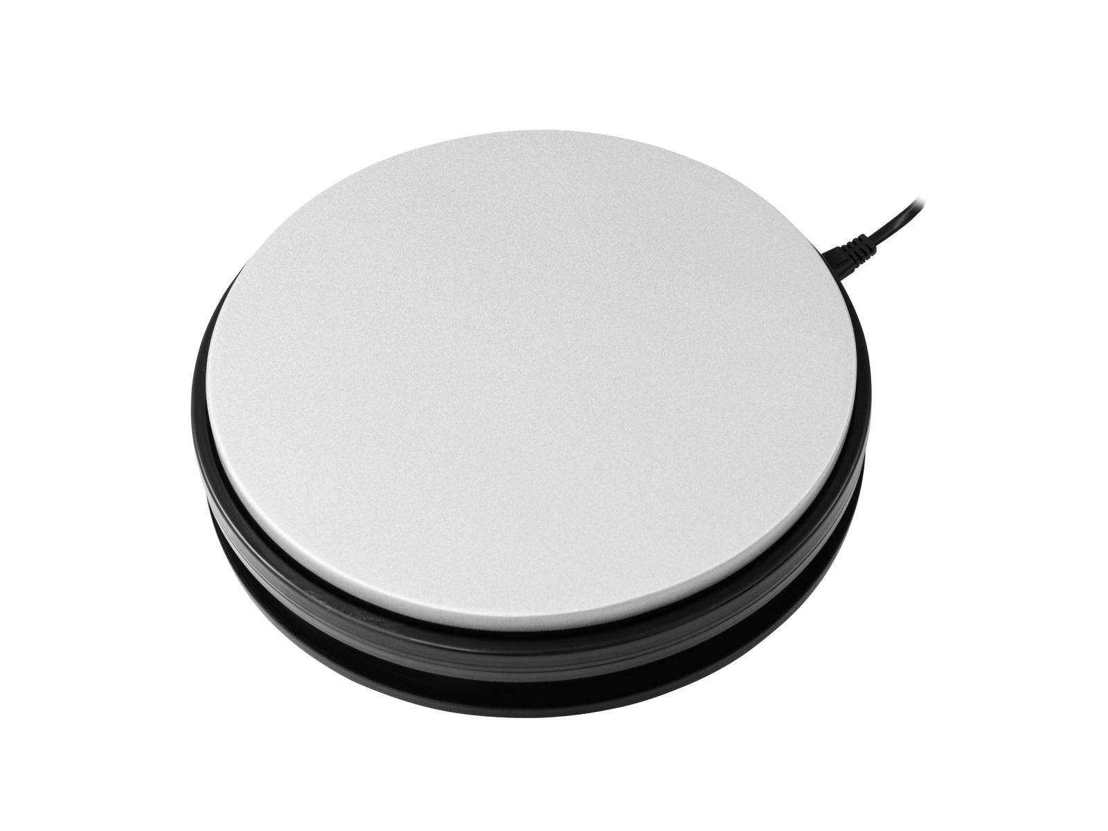 Un objet rond, plat, blanc avec un bord noir et un câble attaché, probablement un appareil électrique.