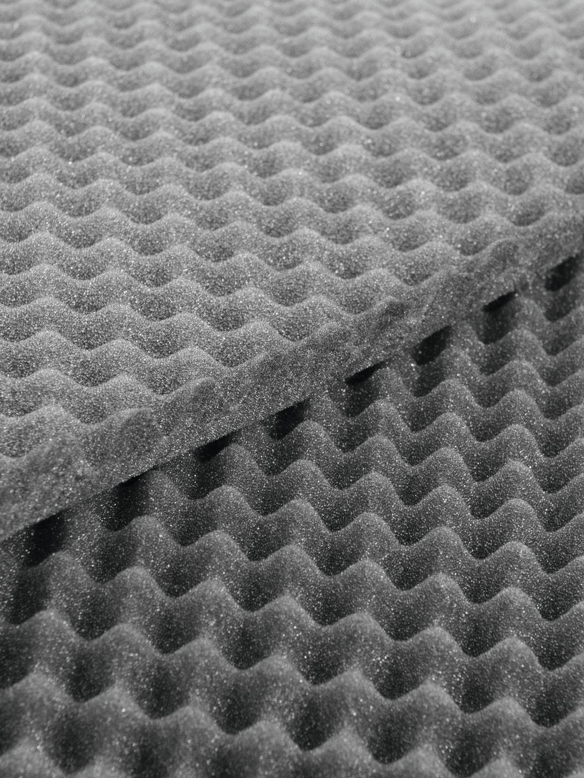 Plaques de mousse acoustique grise avec motif ondulé pour l'absorption sonore.