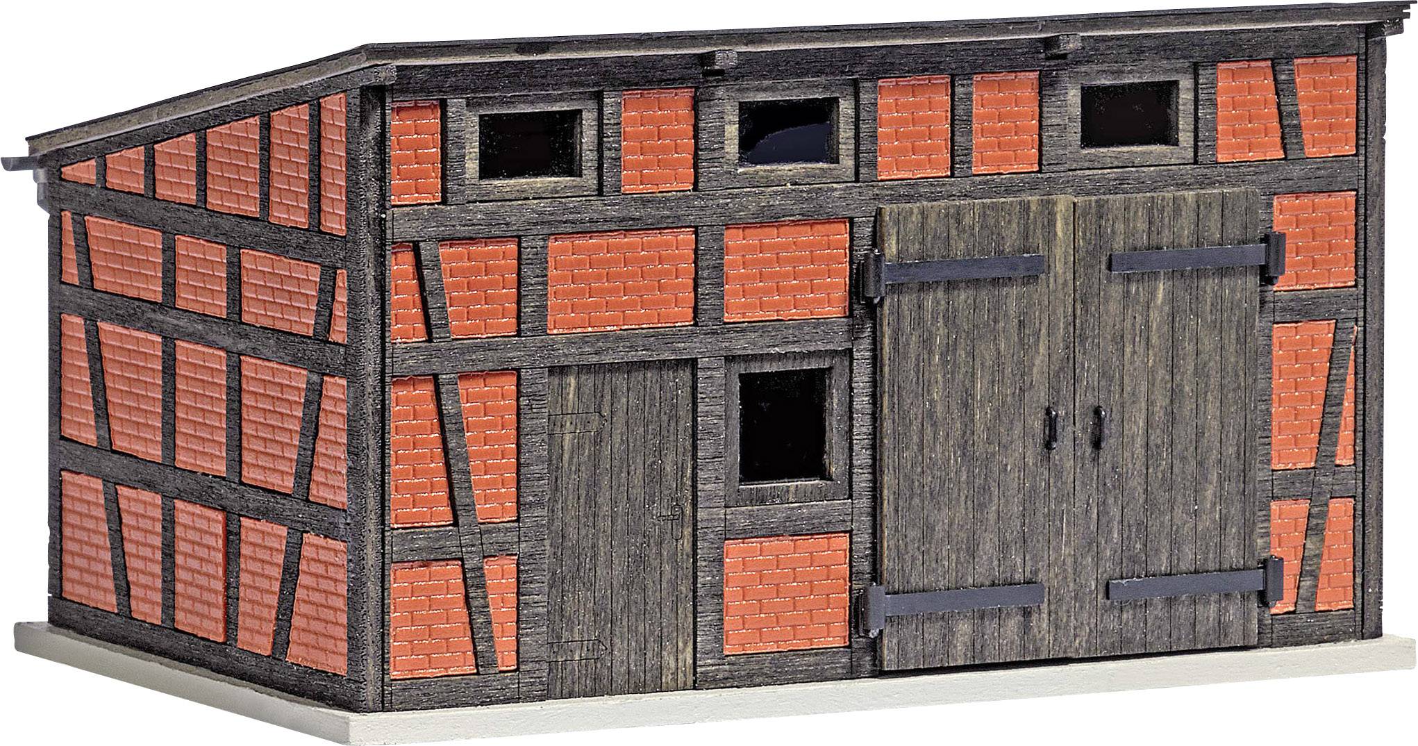Une maisonnette miniature avec un motif de briques rouges et des portes en bois, un bâtiment plat sans fenêtres, adapté pour les trains miniatures.
