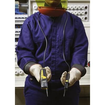 Un électricien en tenue de protection tient un testeur de tension devant un coffret électrique.