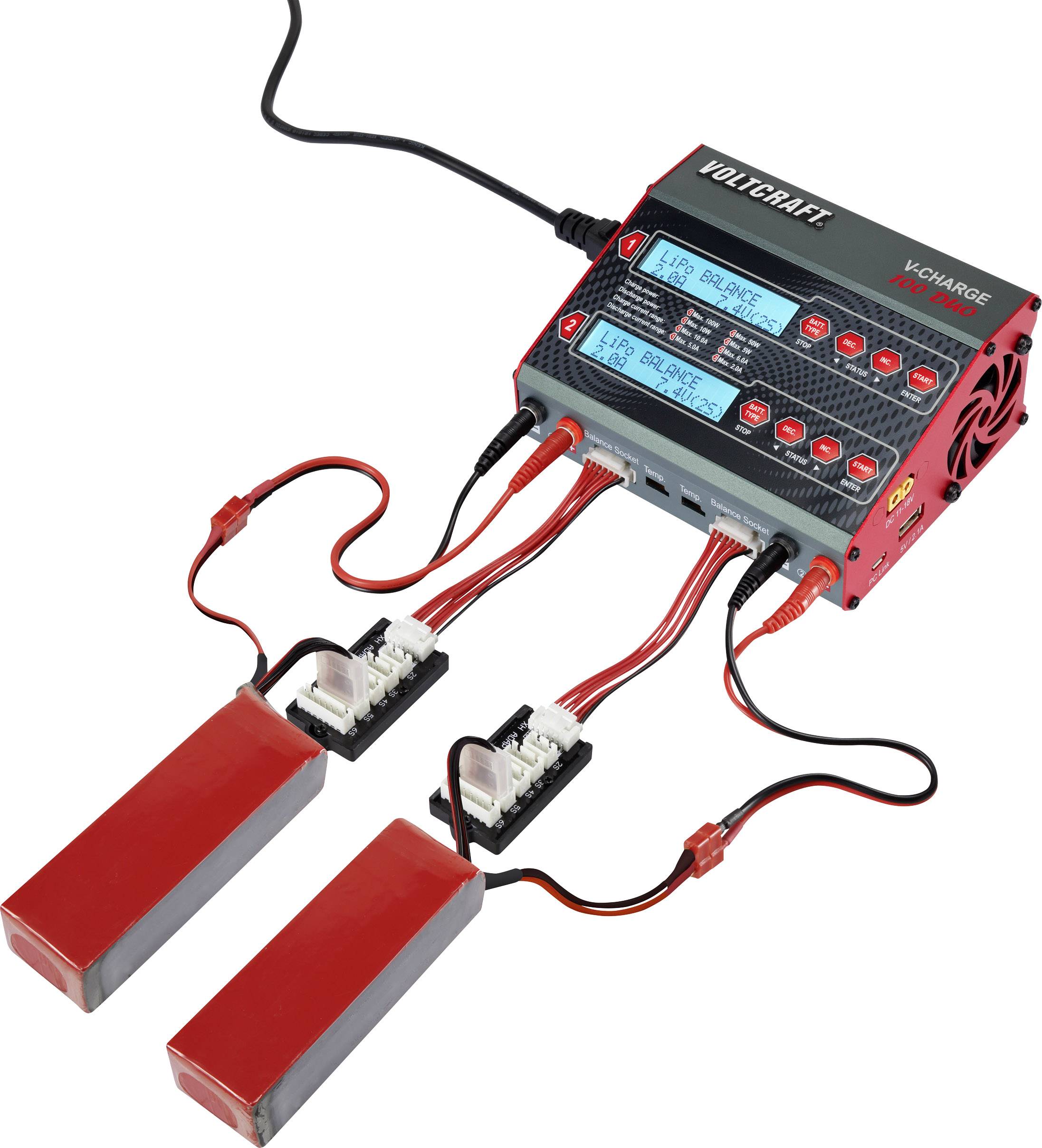 Un chargeur de la marque Voltcraft avec deux batteries connectées. Les écrans affichent des informations de charge pour des applications de modélisme.