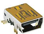 Un connecteur USB rectangulaire dans un boîtier métallique avec des contacts dorés, monté sur une carte de circuit imprimé pour des connexions électroniques.