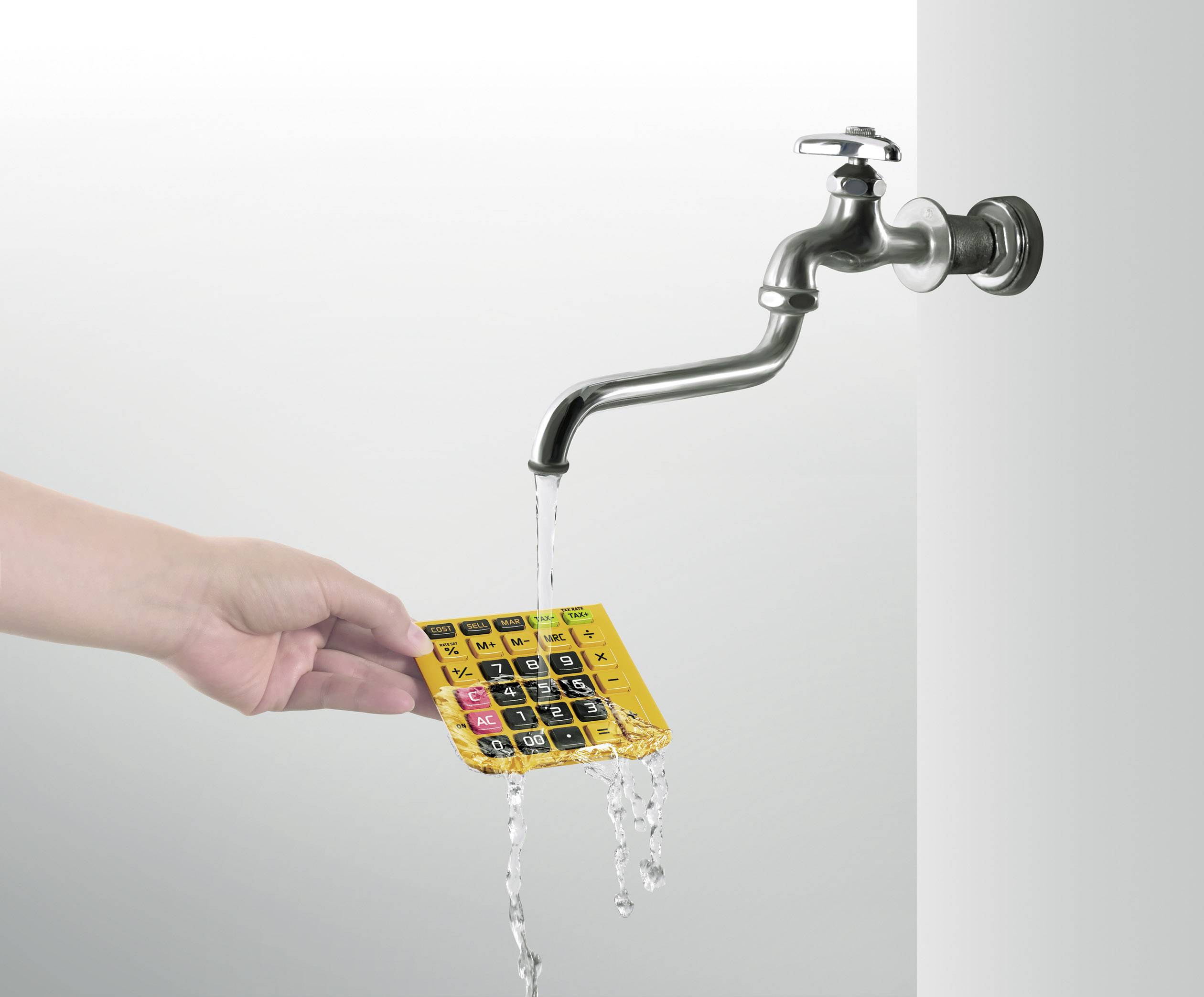 Une main tient une calculatrice jaune étanche sous l'eau courante d'un robinet.
