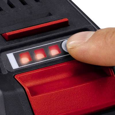 Un doigt appuie sur un bouton d'un appareil pour allumer quatre voyants LED rouges.